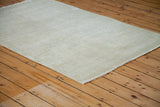 Light, distressed Oushak rug with faded blanched white ivory and grey hues.