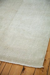 Distressed pile texture with blanched ivory and platinum tones, showing fringed edge.