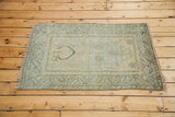 Distressed vintage Oushak rug displaying a soft silver field with geometric star motifs.