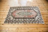 Decorative distressed Oushak rug featuring brick, pale rose, chocolate, and ivory tones.