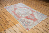 Distressed pile, ivory border, and brick red pattern detail of the vintage Oushak rug.