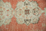 Intricate medallion motif and abrash on a vintage Oushak rug's brick orange field.