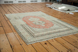 Visible abrash on brick orange red field and intricate dark border of a vintage Oushak rug.