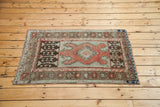 Vintage Oushak rug with tribal salmon-coral medallion and dark brown geometric panels.