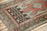 Vintage Oushak rug featuring tribal geometric motifs in dark brown, muted terracotta, and light sage.