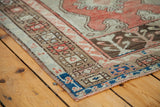 Detailed blue, coral, and brown geometric border of a vintage Oushak rug.