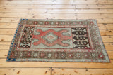 Vintage Oushak rug corner with tribal brown, soft coral, and blue-grey geometric patterns.