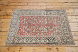 Distressed red field with scrolling ivory vines and grey, ivory geometric border motif.
