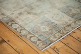 Bronze floral border and faded blue patterns on a vintage Oushak rug.