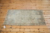Hand-knotted Oushak rug corner featuring muted bronze, beige, blue and intricate border.