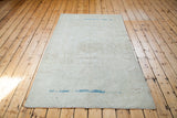 Aqua abrash and faded sandy beige patterns on a blanched white distressed Oushak rug.