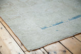 Distressed pile of an Oushak rug with sandy beige tones and aqua blue abrash.