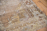 Distressed Oushak rug detail, showing worn pile texture with silver, beige, and bronze colors.