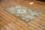 Distressed Oushak rug's geometric border with pale silver and bronze earth tones.