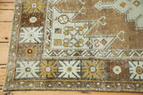 Geometric border and field patterns with distressed texture in pale silver, bronze, and brown.