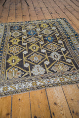 Geometric palmettes and serrated leaf motifs on a charcoal Caucasian Cabistan rug.