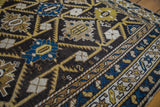 Charcoal field with geometric palmettes, serrated leaf motifs, and patterned border.