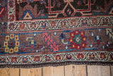 Patinaed wool pile displaying complex geometric and floral border patterns of an antique Bidjar rug.