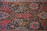 Intricate red, blue, and gold stylized motifs in an antique Bidjar gerus design.