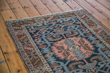 Vintage Heriz rug's coral central medallion, unique aqua scrolling vines, and classic serrated border.