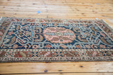 Vintage Heriz rug's serrated leaf border and aqua scrolling vines on navy field.