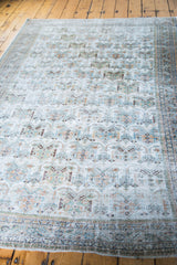 Repeating geometric pattern and distressed texture on a light ivory Afshar rug.