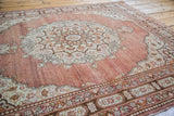 Ornate medallion, cinnabar red field, and pearl floral details of the antique Tabriz rug.