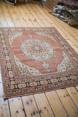 Antique Tabriz rug detail showing ornate medallion, rich cinnabar red field, and pearl floral border.