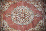 Ornate medallion and intricate floral cartouches in the antique Tabriz rug's pearl border.