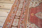 Antique Tabriz rug detail: pearl border with floral cartouches and cinnabar red field.
