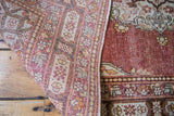 Antique Persian Tabriz rug's hand-knotted reverse, revealing cinnabar red floral pile.
