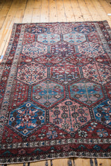 Distressed Baktiary rug panel design featuring faded tree and pinwheel motifs.