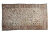Distressed vintage Mahal carpet, large scale floral pattern in faded beige, brown, charcoal tones.
