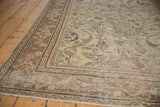 Distressed vintage Mahal carpet, showcasing worn pile, muted beige, and faded terracotta motifs.