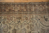 Distressed Mahal rug with worn pile, muted sandy tones, and curvilinear border patterns.