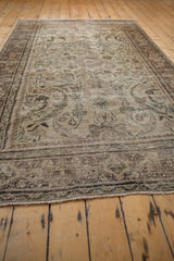 Distressed vintage Mahal rug edge showing worn fringe and faded border pattern.