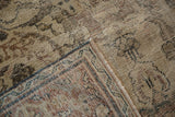 Distressed vintage Persian Mahal rug corner with aged texture and muted neutral colors.