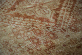 Worn orange rust garden design on golden ivory Joshegan rug pile.