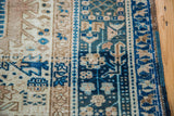 Striped geometric border patterns in blues, ivory, and beige on a Persian Karaja rug.