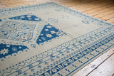 Distressed vintage Oushak rug with geometric blue and beige medallion and borders.