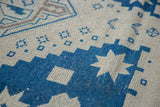 Distressed blue geometric motifs and textured pile on a vintage Turkish Oushak carpet.