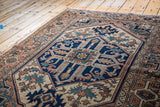 Vintage Serapi rug corner: stylized geometric motif in terra cotta, teal, and ivory.