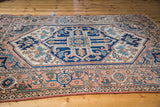 Stylized geometric Serapi rug medallion in softened terra cotta, ivory, teal, deep blue.