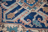 Vintage Serapi rug's stylized geometric motifs in blue, terra cotta, teal, and ivory.
