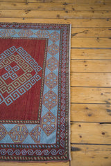 Deep red field with intricate geometric patterns and soft light blue border.