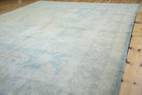 Vintage Oushak rug's side edge with aqua seafoam binding and faded large scale motif.