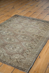 Geometric gul medallions and intricate border of the vintage Turkmen rug in bronze tones.
