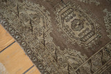 Hand-knotted vintage Turkmen rug showing geometric gul motifs and bronze brown palette.