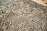 Angled close-up of geometric gul patterns and bronze brown pile texture.