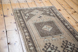 Vintage Oushak runner's geometric prayer design in warm beige and dark brown tones.